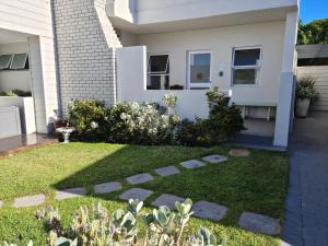 a garden in front of a house at South Point Guest Lodge in Agulhas
