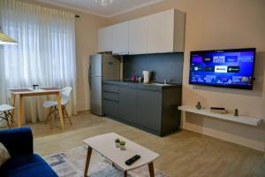 een woonkamer met een keuken en een tv aan de muur bij Brian's Apartment in Tirana in Tirana
