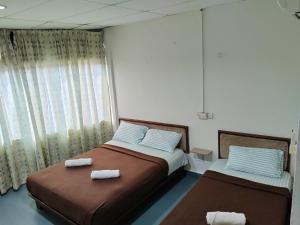 a bedroom with two beds with towels on them at Hotel Kenangan in Kota Bharu
