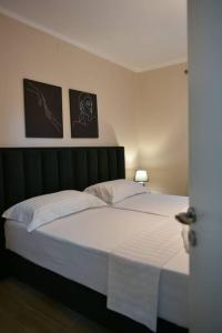 een bed in een slaapkamer met twee foto's aan de muur bij Brian's Apartment in Tirana in Tirana