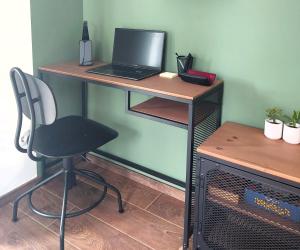 a desk with a laptop and a chair on it at Tilia Home in Vrnjačka Banja