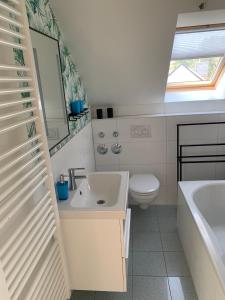 a bathroom with a sink and a toilet and a mirror at FeWo Lust auf Laboe in Laboe