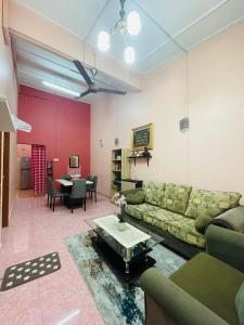 sala de estar con sofá y mesa en Kota Bharu Homestay, en Kota Bharu