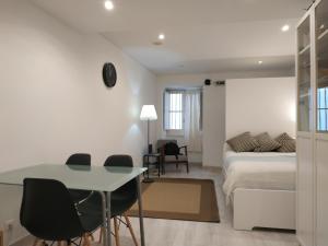 ein Wohnzimmer mit einem Bett, einem Tisch und Stühlen in der Unterkunft STUDIO MADALENA in Lissabon