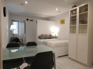 Schlafzimmer mit einem Bett, einem Schreibtisch und Stühlen in der Unterkunft STUDIO MADALENA in Lissabon