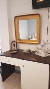 un espejo sentado en la parte superior de un mostrador en una habitación en Embati Folegandros rooms en Chora Folegandros
