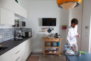 a woman standing in a kitchen with a table at Casa mia in Puglia in Conversano