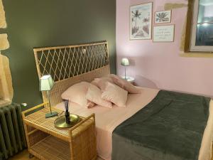 1 dormitorio con cama con almohadas y mesa en Chambre calme Ouest Lyonnais, en Lentilly