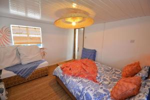 希內斯的住宿－Pips Chalet rest and relax in the Isle of Sheppey，一间卧室配有一张床、一张沙发和一盏灯