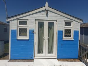 a blue and white shed with a door at Pips Chalet rest and relax in the Isle of Sheppey in Sheerness