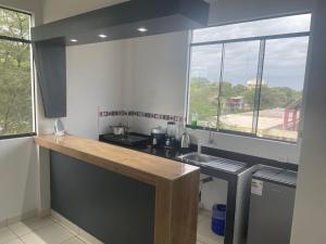 a kitchen with a counter and a sink and a window at Casa Mimaya in Piura