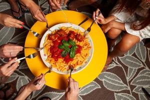 Eine Gruppe von Leuten, die eine Schüssel Pasta essen. in der Unterkunft Casa mia in Puglia in Conversano