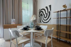uma sala de jantar com uma mesa branca e cadeiras em 46 m2 central bright apartment with a balcony em Viena