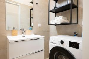 uma lavandaria com uma máquina de lavar roupa e um lavatório em 46 m2 central bright apartment with a balcony em Viena