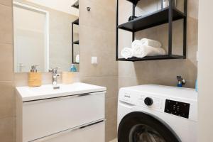 een wasruimte met een wasmachine en een gootsteen bij Contemporary 1-Bed Apartment with Balcony in the Heart of Vienna in Wenen