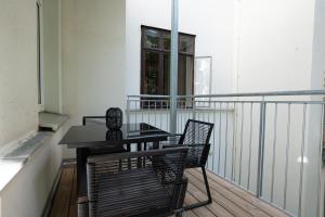 einen Balkon mit einem Tisch und Stühlen sowie einem Fenster in der Unterkunft 46 m2 central bright apartment with a balcony in Wien