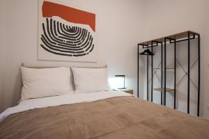 een slaapkamer met een bed en een schilderij aan de muur bij Contemporary 1-Bed Apartment with Balcony in the Heart of Vienna in Wenen +26 foto's
