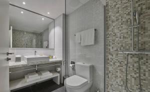 een badkamer met een toilet, een wastafel en een douche bij Marriott Hotel The Hague in Den Haag