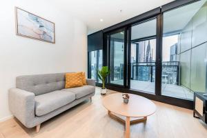 a living room with a couch and a table at Homely Urban Oasis in Melbourne