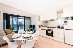 een keuken en een woonkamer met een tafel en stoelen bij Homely Urban Oasis in Melbourne