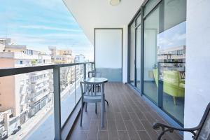 een balkon met een tafel en stoelen in een gebouw bij Colorful 3BR with MAMAD by HolyGuest in Tel Aviv