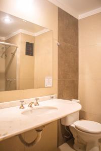 a bathroom with a sink and a toilet and a mirror at Hotel Balneário in Marcelino Ramos