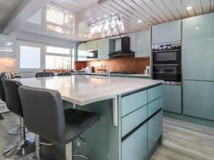 a kitchen with a large island with chairs in it at 26 North Promenade in Cleveleys