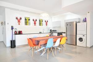 uma cozinha com uma mesa e cadeiras e um frigorífico em Colorful 3BR with MAMAD by HolyGuest em Tel Aviv