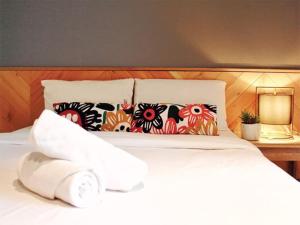 een wit bed met kussens erop bij The Finn Hotel / เดอะฟินน์โฮเทล in Ban Liap
