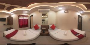 um quarto com 2 camas e almofadas vermelhas em Hotel Briteway em Mumbai