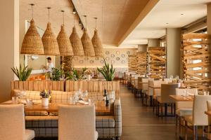 a restaurant with tables and chairs and a woman in the background at Octant Evora in Évora