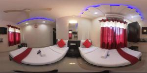 2 łóżka w pokoju z czerwonymi zasłonami w obiekcie Hotel Briteway w Bombaju