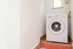uma máquina de lavar roupa num canto de um quarto em Alcam Torrent em Barcelona