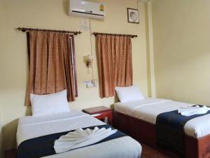 Thipphaphone Guesthouse في باكبنج: غرفة فندقية بسريرين ونافذة