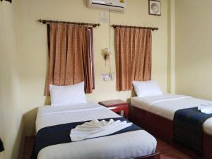 Thipphaphone Guesthouse في باكبنج: غرفة فندقية بسريرين ونافذة