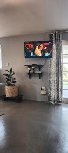 a living room with a flat screen tv on the wall at Wylie Hall Guesthouse in Durban