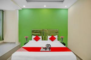 um quarto com uma cama com uma parede vermelha e verde em Flagship Grand Imperial Near Worlds Of Wonder em Kālkāji Devi