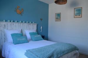 una camera blu con un letto con due cuscini blu di Chez charlotte a Cherrueix