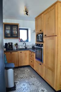 a kitchen with wooden cabinets and a sink at Chez charlotte in Cherrueix