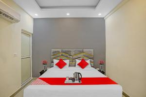 um quarto com uma grande cama branca com almofadas vermelhas em Flagship Grand Imperial Near Worlds Of Wonder em Kālkāji Devi