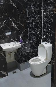 un bagno bianco e nero con servizi igienici e lavandino di Hotel Kenangan a Kota Bharu