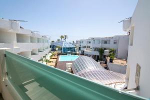 uitzicht op een zwembad vanaf een balkon van een gebouw bij Apartamentos Bora Bora - Adults Only in Playa d'en Bossa