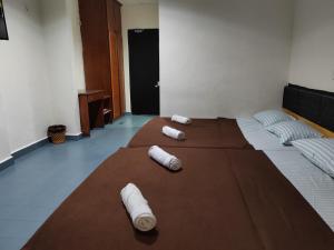 Una habitación con una cama con toallas enrolladas. en Hotel Kenangan, en Kota Bharu