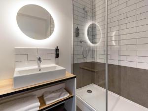 y baño blanco con lavabo y ducha. en Ibis Marseille Marignane Technopole en Marignane