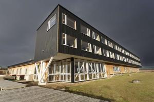 ein großes schwarzes Gebäude mit Fenstern auf einem Feld in der Unterkunft Best Western Patagonia in Puerto Natales