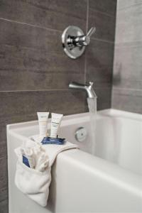 a bath tub with two towels and a faucet at Park Inn by Radisson Edmonton Airport in Leduc