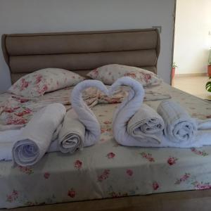 Una cama con dos cisnes hechos de toallas. en Lion's rooms, en Vlorë