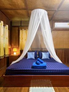 1 dormitorio con 1 cama con mosquitera en Chaweang cozy house 1 km.Lotus, en Ban Ko Khwan
