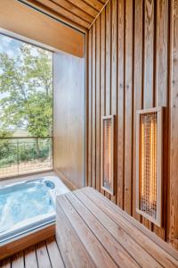 a hot tub in a room with a large window at Kapolcsi Sziklák in Vigántpetend