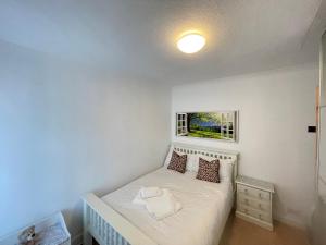 um pequeno quarto com uma cama e uma janela em Addlestone Tranquil Spacious Three Bedroom Bungalow em Addlestone